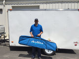 SkyVac customer holding the SkyVac Pole Bag in front of his trailer