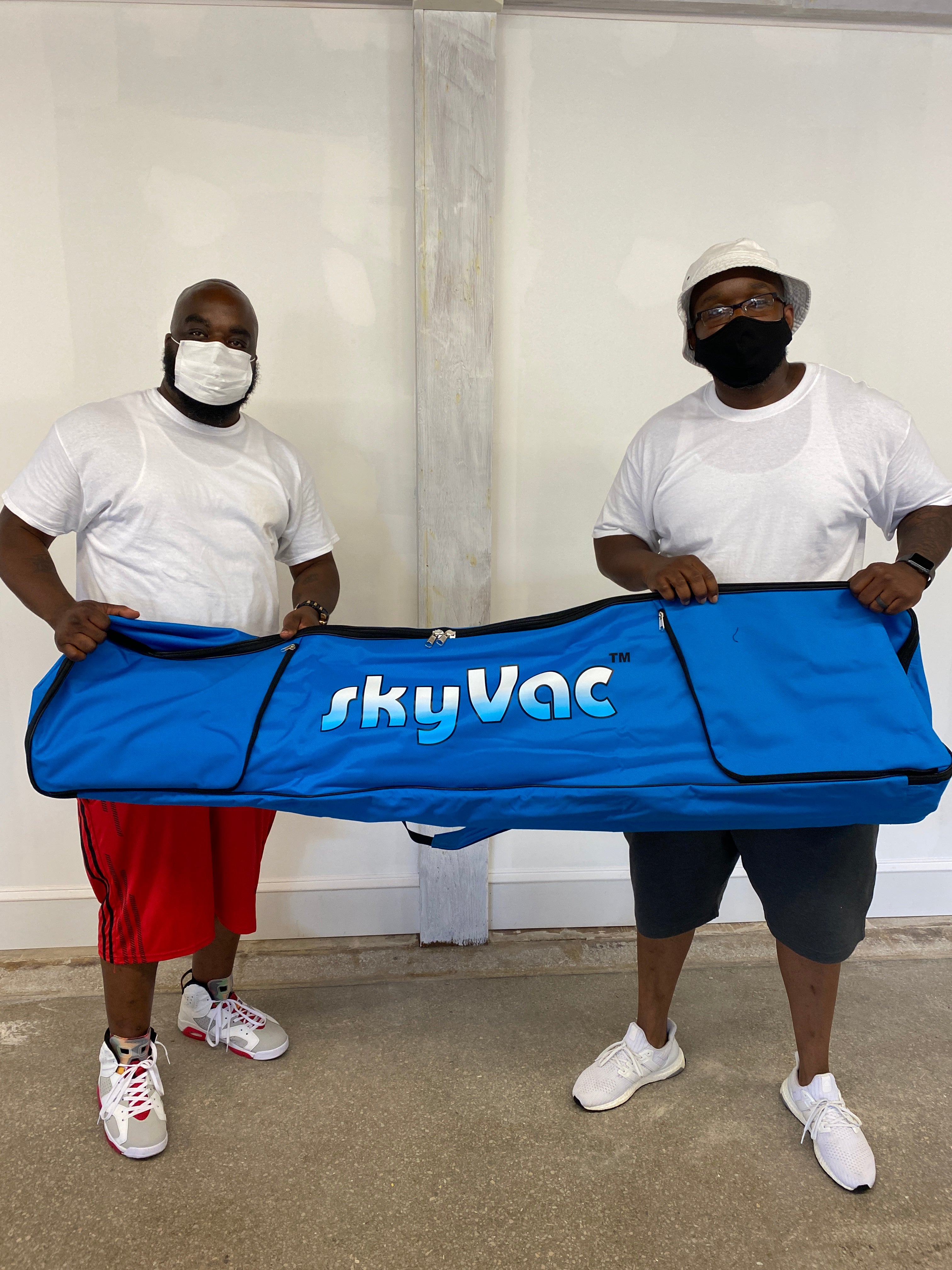 SkyVac customers holding the pole bag
